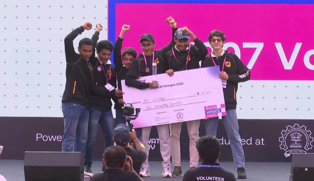 Team VoltEdge celebrating with raised fists on stage at IIT Bombay